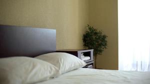 a bedroom with a bed and a plant next to a window at Hostal Paraíso Vip in Portoviejo