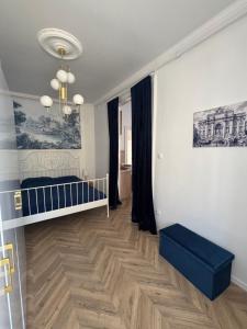 a bedroom with a bed and a crib in a room at Katerina Apartman in Gyula