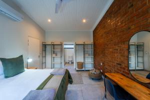 a bedroom with a bed and a brick wall at The Pods Victoria Falls in Victoria Falls +30 photos