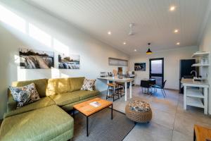 a living room with a couch and a table at The Pods Victoria Falls in Victoria Falls