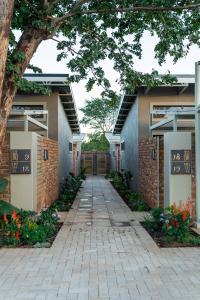 a walkway leading to a building with a tree at The Pods Victoria Falls in Victoria Falls
