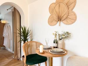 a dining room with a wooden table and green chairs at La Chaumière des Marais Escapade romantique & jacuzzi privatif in La Chapelle-des-Marais +27 photos