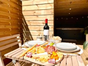 a table with a plate of food and a bottle of wine at La Chaumière des Marais Escapade romantique & jacuzzi privatif in La Chapelle-des-Marais