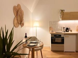 a small kitchen with a table with a bottle of wine at La Chaumière des Marais Escapade romantique & jacuzzi privatif in La Chapelle-des-Marais