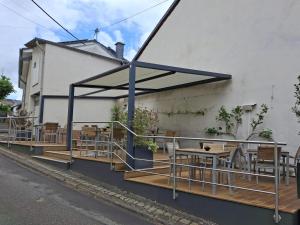 a patio with tables and chairs on the side of a building at Linden's Pension-Restaurant in Ayl +12 photos