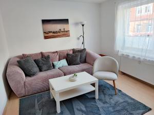 a living room with a couch and a table and a chair at Ferienwohnung Amelie in Ribnitz-Damgarten