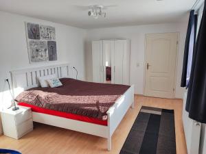 a white bedroom with a bed and a black rug at Ferienwohnung Amelie in Ribnitz-Damgarten