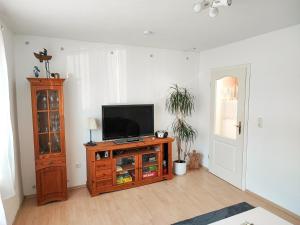 a living room with a television on a wooden entertainment center at Ferienwohnung Amelie in Ribnitz-Damgarten +5 photos