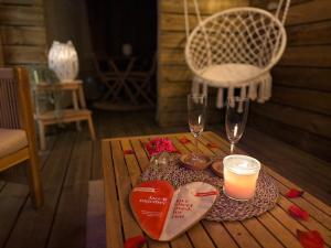 a table with two hearts and two glasses and a chandelier at La Chaumière des Marais Escapade romantique & jacuzzi privatif in La Chapelle-des-Marais