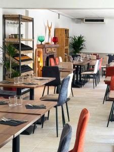 ein Restaurant mit Tischen, Stühlen und einem Kamin in der Unterkunft Hôtel Juantorena in Saint-Étienne-de-Baïgorry