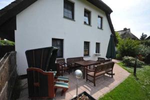 a patio with chairs and a table in front of a house at Ruegen_Fewo 233 in Groß Zicker