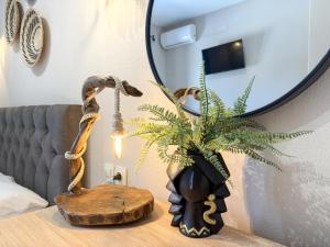 a table with a mirror and a plant on it at GreKa apartments in Kalives Poligirou