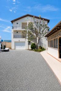 a white house with a tree and a driveway at Casa Irina 2Mai in 2 Mai