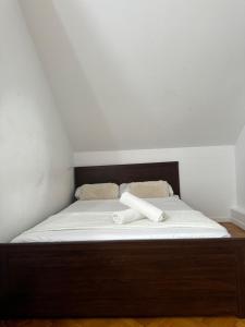 a bed with a wooden frame and white sheets at Pisos Baraja Gl in Madrid