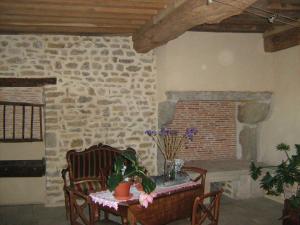 a living room with a table and a brick fireplace at La Ferme du Mont in Foissy +43 photos