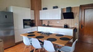 a kitchen with a wooden table and white cabinets at Casa Katarina Beach Apartment in Silvi Marina +30 photos