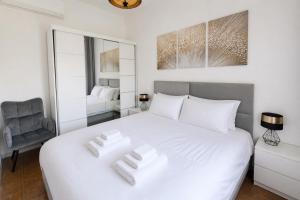 a bedroom with a white bed and a chair at Casa Katarina Beach Apartment in Silvi Marina
