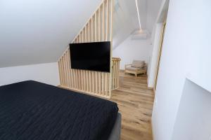 a bedroom with a bed and a flat screen tv at Cirus Riverfront Kolpa & Rafting in Kočevje