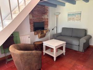 a living room with a couch and a table at Gîte Landes d armagnac in Roquefort