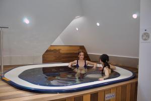 two women in a jacuzzi in a swimming pool at Turul Villa in Sovata