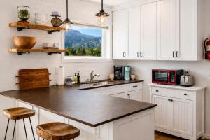a kitchen with white cabinets and a sink and a microwave at Berg Haus Home in Leavenworth