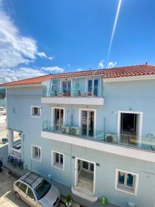 a white building with a car parked in a parking lot at King A in Argostoli