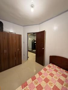 a bedroom with a bed and a door to a kitchen at Rose Haven Staycation Panabo in Panabo