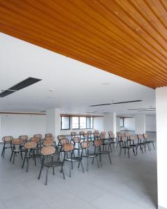 a room with a bunch of chairs and tables at E.05 City Inn in Alwaye