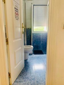 a bathroom with a toilet and a window at Pisos Baraja Gl in Madrid
