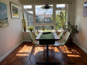 a table and chairs in a room with a window at Mid-Century Gem Steps from the Beach in Edinburgh