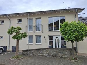 a house with two trees in front of it at Linden's Pension-Restaurant in Ayl