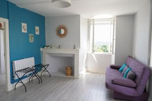a living room with a purple couch and a fireplace at Maison Hormidas in Crouseilles +43 photos