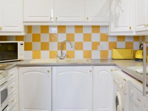 a kitchen with white cabinets and a sink at Foulston Apt- Cv12 in Liskeard