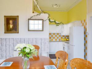 a kitchen with a table with a vase of flowers on it at Foulston Apt- Cv12 in Liskeard