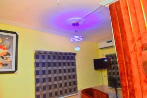 a room with a ceiling with a purple light at Clint Cottage Hotel in Odo
