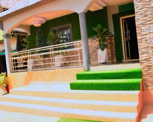 a house with green steps and a building at Clint Cottage Hotel in Odo