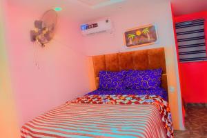 a bedroom with a bed in a room with a fan at Clint Cottage Hotel in Odo