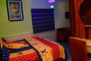 a bedroom with a bed with a colorful blanket at Clint Cottage Hotel in Odo +7 photos