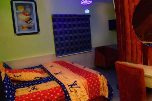 a bedroom with a bed with a quilt on it at Clint Cottage Hotel in Odo