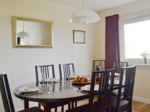 a dining room table with a bowl of fruit on it at Tall Pines in Carrbridge