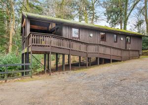 a large wooden house with a large deck at Brockwood Hall Lodges in Silecroft