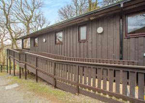 a wooden house with a wooden fence around it at Brockwood Hall Lodges in Silecroft