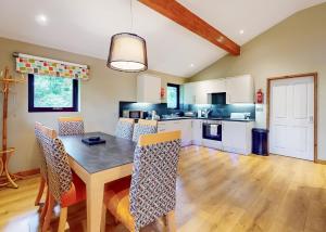 a kitchen with a dining room table and chairs at Brockwood Hall Lodges in Silecroft +149 photos