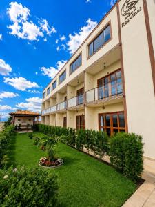 a building with a green lawn in front of it at Apartamentos Recanto do Rouxinol em Serra de São Bento RN in Serra de São Bento