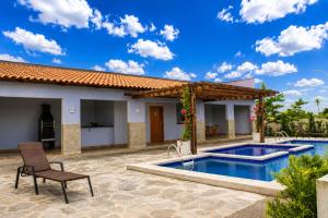 a patio with a chair and a swimming pool at Apartamentos Recanto do Rouxinol em Serra de São Bento RN in Serra de São Bento