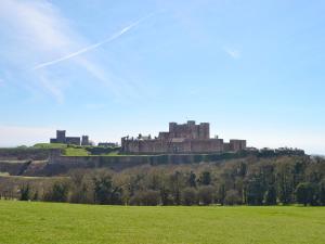 a castle on a hill with a green field at The Barn At Fishponds in Brook