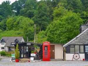 an old red phone booth in front of a house at Gamekeepers Apt - Cv20 in Liskeard