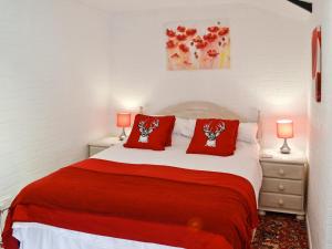 a bedroom with a bed with red pillows on it at Gamekeepers Apt - Cv20 in Liskeard