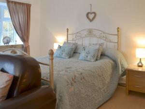 a bedroom with a bed with blue pillows and a chair at Kingfisher Apt - B4866 in Liskeard