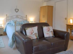 a brown leather chair in a bedroom with a bed at Kingfisher Apt - B4866 in Liskeard